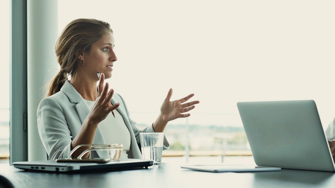 Businesswoman having meeting with laptops in boardroom